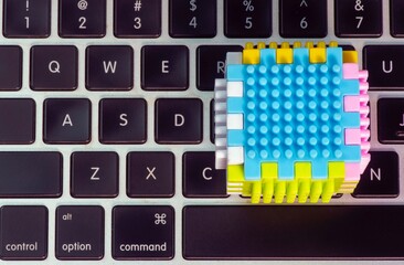 Top view of colorful building sets on a laptop keyboard, education concept