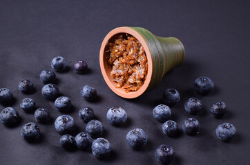 hookah bowl with tobacco on an black background with blueberries
