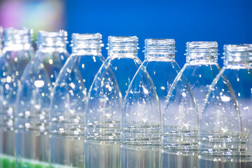 The PET bottles  on the conveyor belt for filling process in the drinking water factory. The hi-technology of plastic bottle manufacturing process.