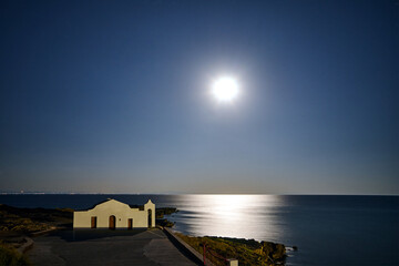 The facade of the Orthodox chapel illuminated by moonlight on the coast of the island of Zakynthos