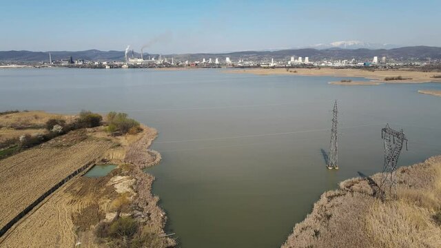 Aerial view of Ramnicu Valcea city in Romania with mountains, Olt river and a power plant