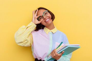 Young mixed race student woman isolated on yellow background excited keeping ok gesture on eye.