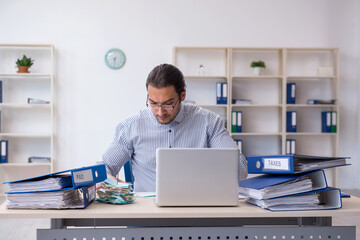 Young male bookkeeper calculating tax payments in the office