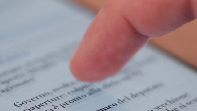 Scrolling news on smartphone screen with finger. Close up of smartphone action. News feed scroll