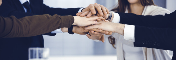 Fototapeta premium Business people group showing teamwork and joining hands or giving five in modern office. Unknown businessman and women making circle with their hands