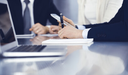 Business people working together at meeting in a modern office. Unknown businessman and woman with colleagues or lawyers at negotiation about contract