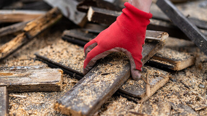 picking up a piece of wood in a glove
