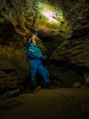 Young girl caver exploring in the cave