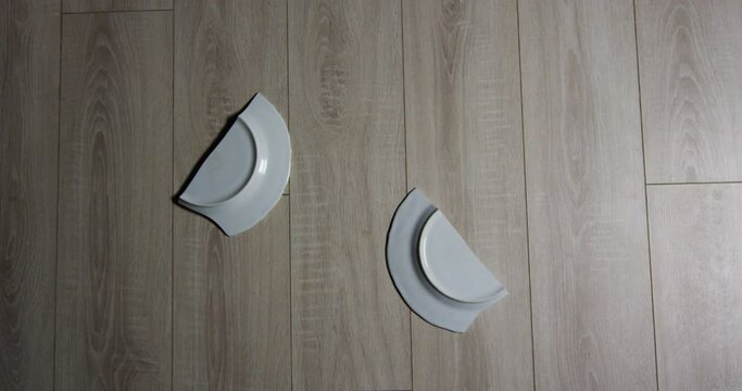 Dish falling to the floor and shattering, slow motion medium shot