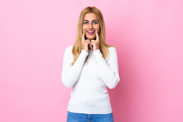 Young Uruguayan blonde woman over isolated pink background smiling with a happy and pleasant expression