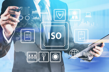 Businessman holding his notes on clipboard and transfer they to glass screen. Researching international standards organization, ISO quality control assurance warranty. Business technology concept