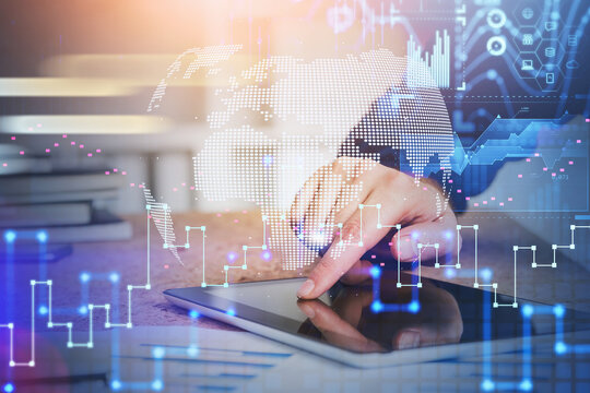 Businessman hand working with tablet device touching the screen by finger. Digital security and data storage concept in business process. Charts and information icons flying in the air.