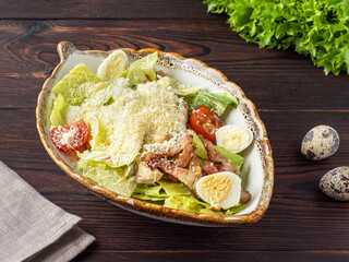  Salad with quail eggs, herbs and cherry on a wooden background. Festive salad. Appetizer for the festive table. Copy space. Rustic style. Space for text.