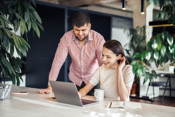 Male and female colleagues working at the table in office