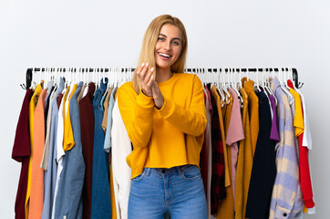 Young Uruguayan blonde woman in a clothing store applauding after presentation in a conference