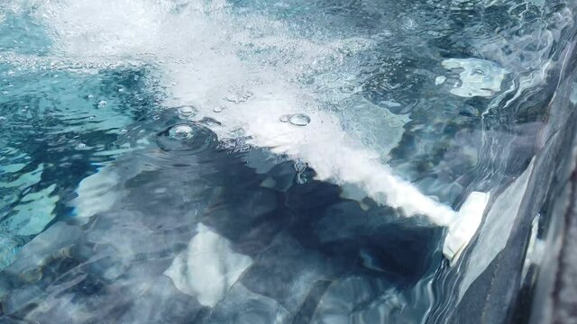 Close up, air bubbles from jacuzzi spa jet in swimming pool.
