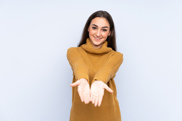 Young caucasian woman isolated on blue background holding copyspace imaginary on the palm to insert...