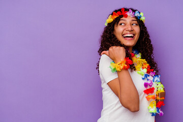 Fototapeta na wymiar Young Hawaiian woman isolated on purple background points with thumb finger away, laughing and carefree.