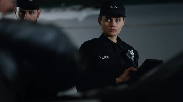 Police team arresting suspect at patrol car. Male cop handcuffing criminal 