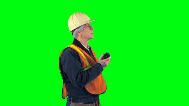 Construction worker talking on radio green screen medium shot.