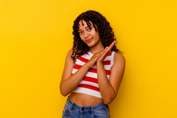 Young mixed race woman isolated on yellow background feeling energetic and comfortable, rubbing hands confident.