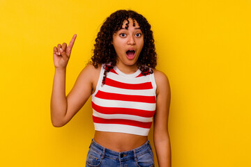 Young mixed race woman isolated on yellow background having some great idea, concept of creativity.