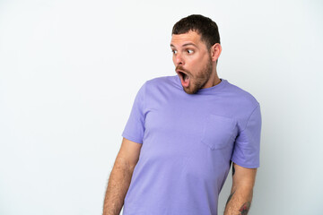 Young Brazilian man isolated on white background doing surprise gesture while looking to the side