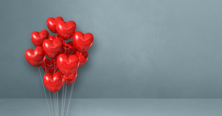 Red heart shape balloons bunch on a grey wall background. Horizontal banner.