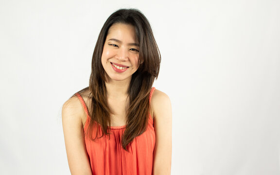 Portrait of Asian beautiful adult long brown hair woman posing, looking to camera, smiling with happiness, wearing orange shirt with isolated white background and blank copy space.