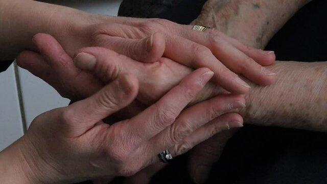 femme tenant les mains d'une grand-m&egrave;re dans les siennes