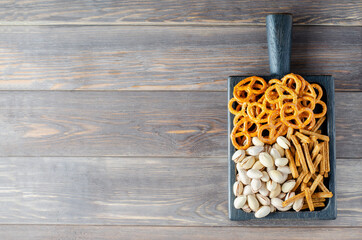 Beer snacks on a brown wooden background. Menu for a pub or restaurant. Copy space