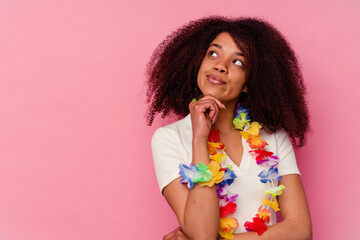 Young african american woman wearing a hawaiian stuff looking sideways with doubtful and skeptical...