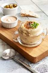  Bowl of hummus, traditional Jewish, Arabian, Middle Eastern food from chick-peas with deeps and with pita flatbread on ceramic tile background. Close up, selective focus