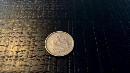 Close up shot of old German 50 pfennig coin with Gerda Johanna. German painter and treeplanter. Black background.