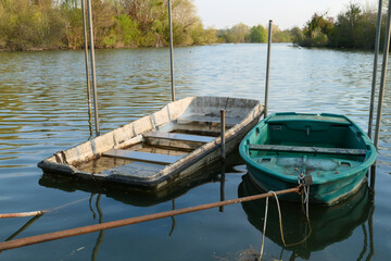 Abandoned rowing boat, isolated on a lake. Two wooden rowboat on water.