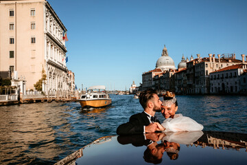 Evening boat trip along the sea bay. Newlyweds travel to Venice. Warm summer evening.