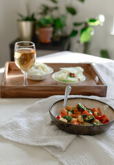 Mixed Bell-pepper Salad with Lettuce egg wrap on a brown tray in room with plants and sunshine through the window