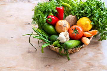 Fresh Vegetables in basket on wooden table. Top view.