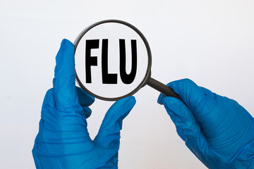 the doctor in gloves holds a magnifying glass with the text FLU . the medicine