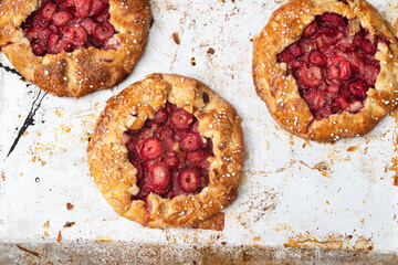 Baked galette with strawberry and rhubarb, pie on a metal background