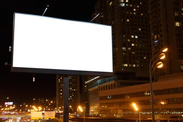 Tuinposter Large horizontal billboard in the night city next to skyscrapers. © JoyNik