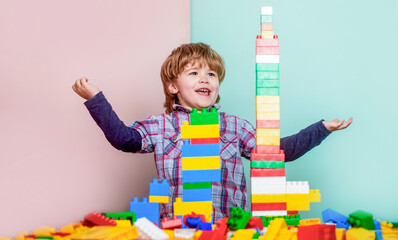 Little boy playing with lots of colorful plastic blocks constructor. Boy playing with construction blocks at kindergarten. Child playing with colorful toy blocks. Educational toys for young children © Yevhen