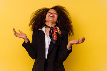 Young African American air hostess isolated on yellow background joyful laughing a lot. Happiness...