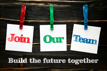 Building the future together, join our team in squre paper notes hanging by clothespin on wood