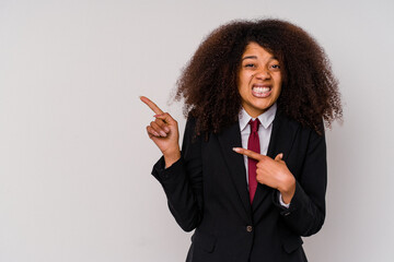 Young African American business woman wearing a suit isolated on white background shocked pointing with index fingers to a copy space.