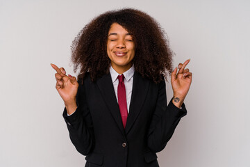 Young African American business woman wearing a suit isolated on white background crossing fingers for having luck
