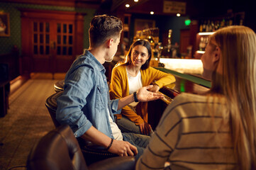 Smiling friends leisures at the counter in bar