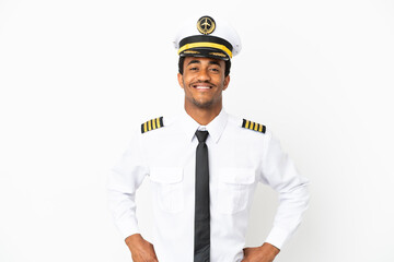 African American Airplane pilot over isolated white background posing with arms at hip and smiling
