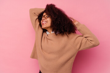 Fototapeta premium Young african american woman isolated on pink background stretching arms, relaxed position.