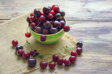 Fresh ripe cherries on a rustic table. Free space for text